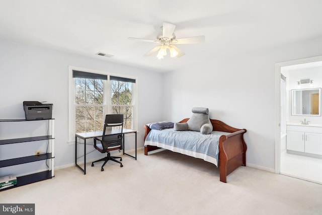 carpeted bedroom featuring ceiling fan, sink, and ensuite bath