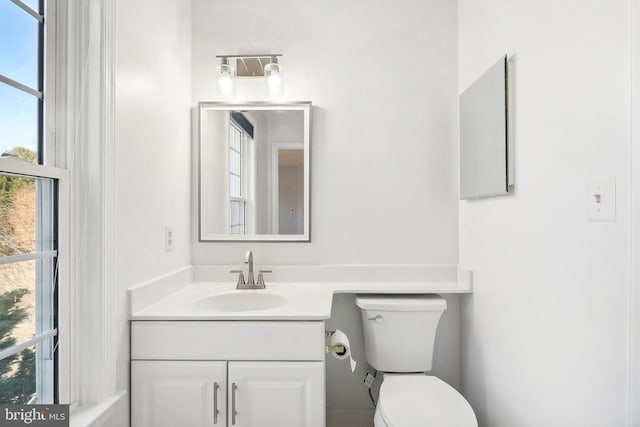 bathroom with vanity, toilet, and a healthy amount of sunlight