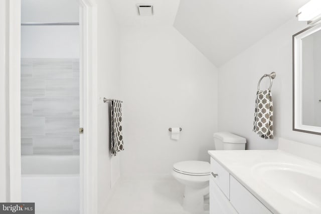 bathroom featuring a bathing tub, vanity, vaulted ceiling, and toilet