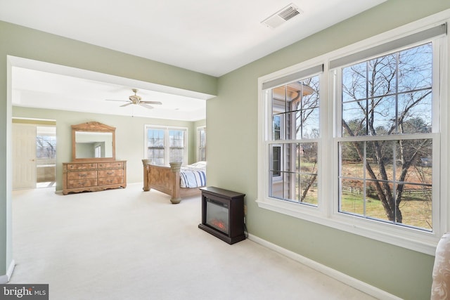 living area with ceiling fan and light colored carpet