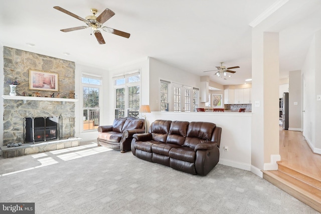 carpeted living room featuring ceiling fan and a fireplace