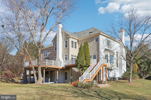 back of property featuring a deck and a lawn