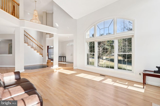 living room featuring light hardwood / wood-style floors and high vaulted ceiling