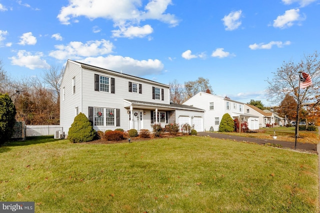 view of front facade featuring a garage, a front yard, and central AC