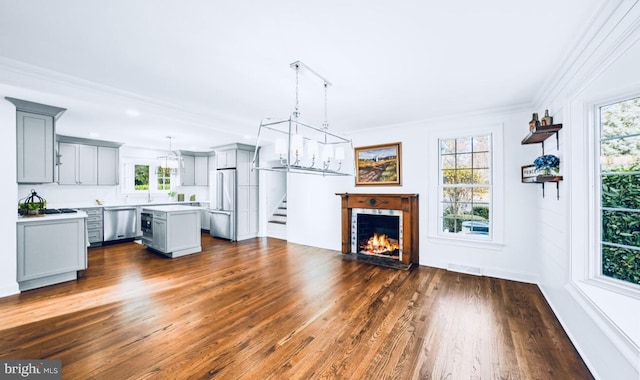 189 Constitution Dr, Princeton, NJ 08540 - unfurnished living room featuring dark wood-style floors, healthy amount of natural light, crown molding, a fireplace with flush hearth, and stairs