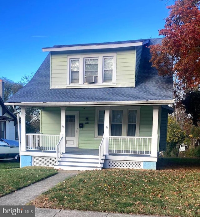 view of front of home featuring cooling unit, a porch, and a front lawn