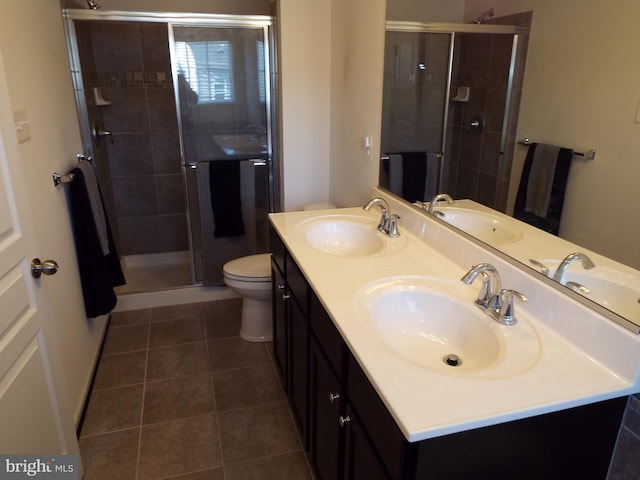 bathroom featuring vanity, toilet, and a shower with shower door