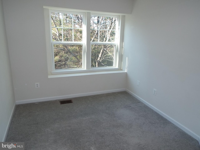 spare room with dark carpet