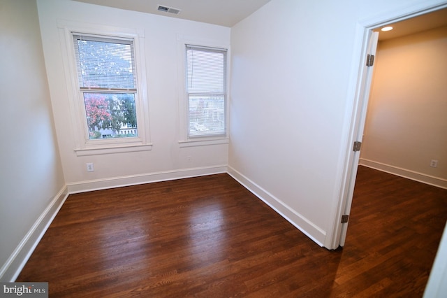 unfurnished room with plenty of natural light and dark wood-type flooring