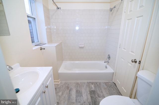 full bathroom featuring vanity, tiled shower / bath, hardwood / wood-style flooring, toilet, and plenty of natural light