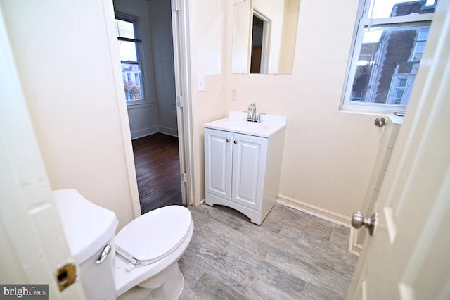 bathroom with vanity, hardwood / wood-style flooring, and toilet