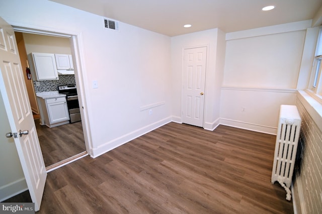 interior space featuring dark hardwood / wood-style flooring and radiator heating unit