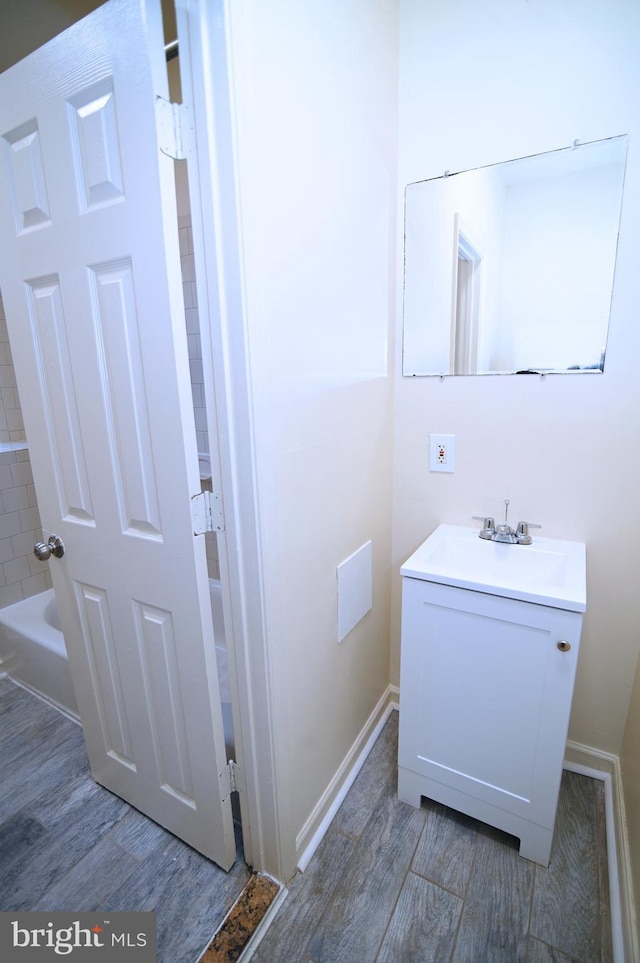 bathroom featuring hardwood / wood-style floors, vanity, and a bath