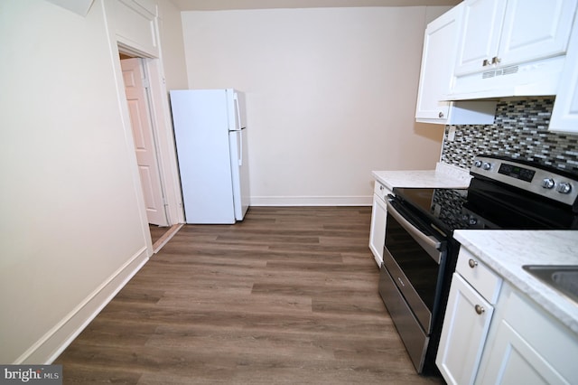 kitchen with dark wood-type flooring, white refrigerator, electric stove, decorative backsplash, and white cabinets