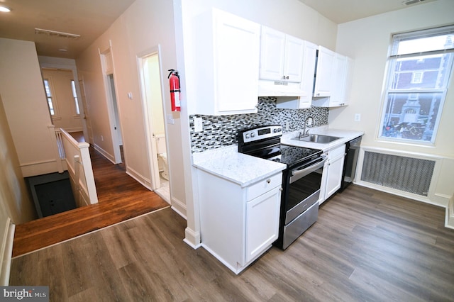 kitchen featuring appliances with stainless steel finishes, custom range hood, dark wood-type flooring, sink, and white cabinets