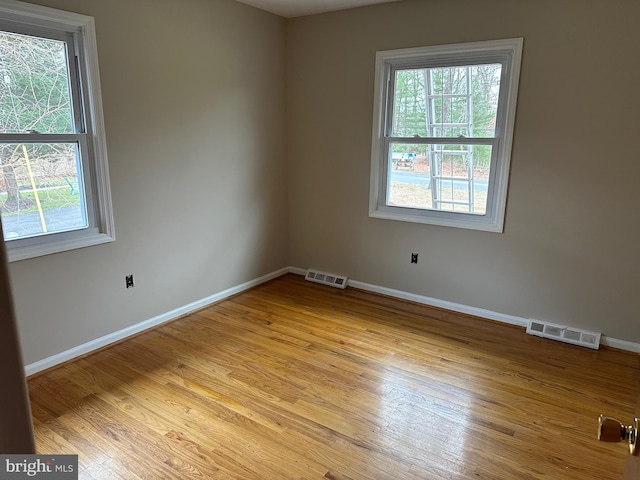 unfurnished room featuring plenty of natural light and light hardwood / wood-style floors