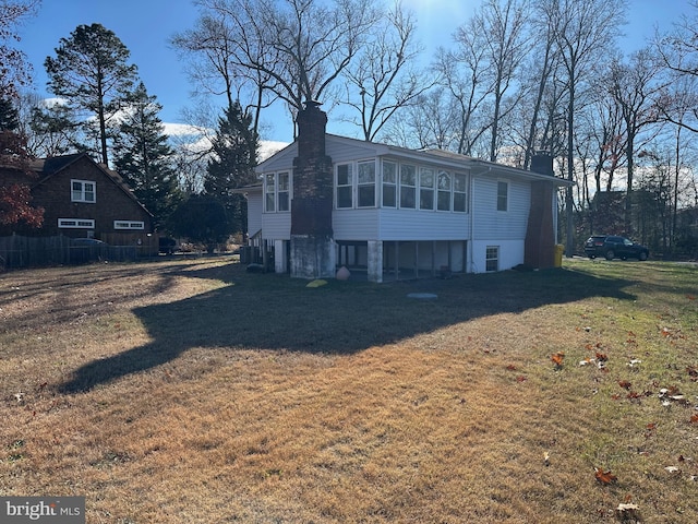 exterior space featuring a sunroom and a yard