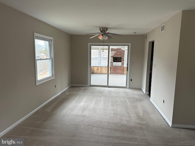 carpeted empty room featuring ceiling fan and a healthy amount of sunlight