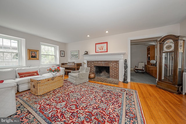 living area featuring a fireplace, wood finished floors, and recessed lighting