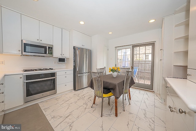 kitchen featuring appliances with stainless steel finishes, marble finish floor, light countertops, white cabinetry, and recessed lighting