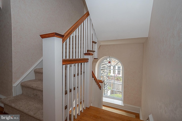 staircase with baseboards and wood finished floors