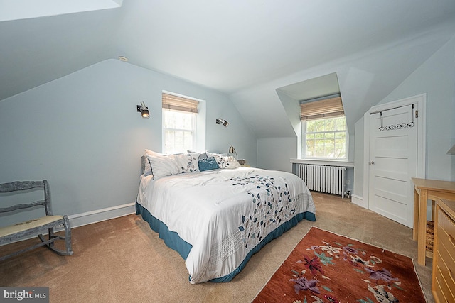 bedroom featuring lofted ceiling, radiator heating unit, baseboards, and carpet flooring