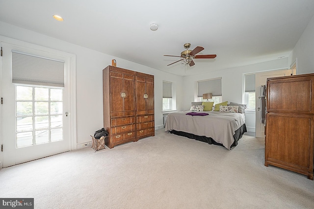 bedroom with multiple windows, a ceiling fan, and light colored carpet