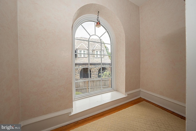 room details featuring baseboards, arched walkways, and wood finished floors