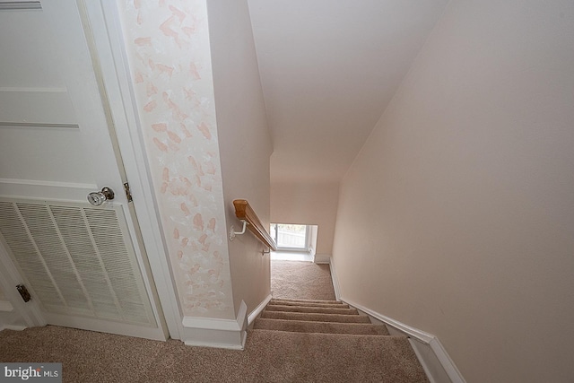 stairs with a skylight, visible vents, baseboards, and carpet flooring