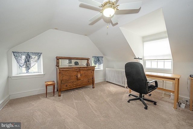 office space featuring lofted ceiling, radiator, light colored carpet, a ceiling fan, and baseboards