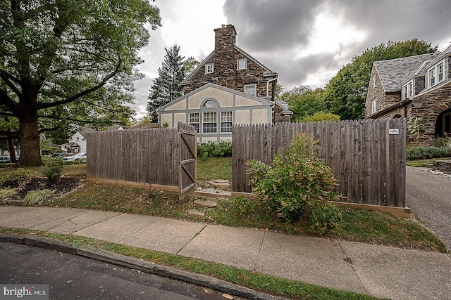 view of front of home with a chimney and fence