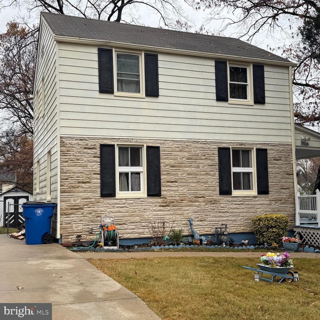 view of front of property with a shed and a front lawn