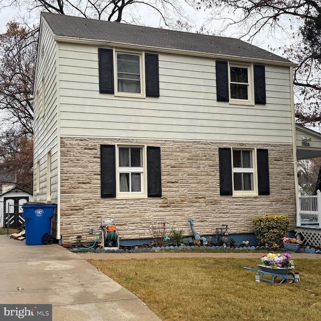 view of front of property with a shed and a front lawn