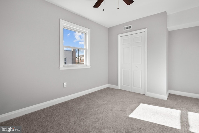 unfurnished bedroom featuring ceiling fan, carpet floors, and a closet