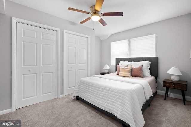 bedroom featuring ceiling fan, carpet floors, and multiple closets