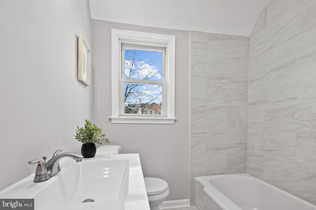 bathroom with vanity, toilet, and a tub