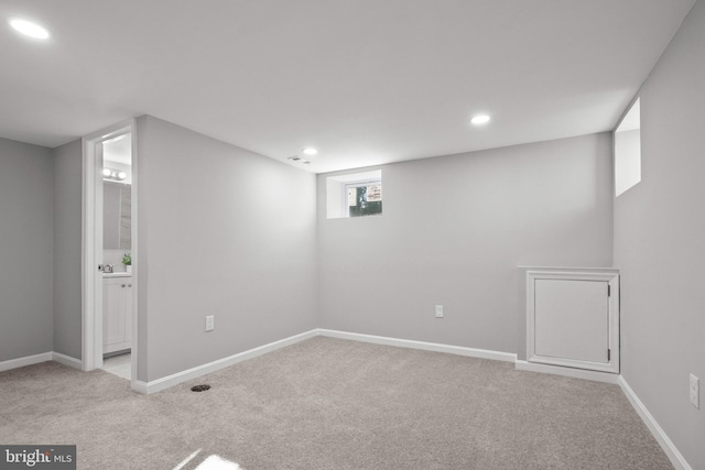 basement featuring light carpet