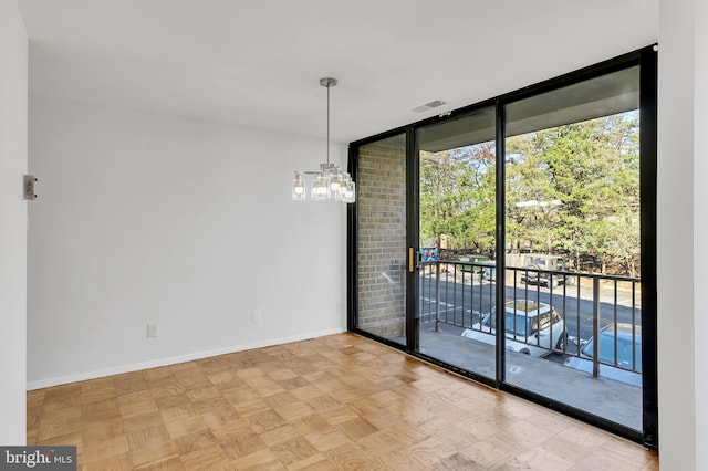 empty room featuring floor to ceiling windows, light parquet flooring, and a notable chandelier