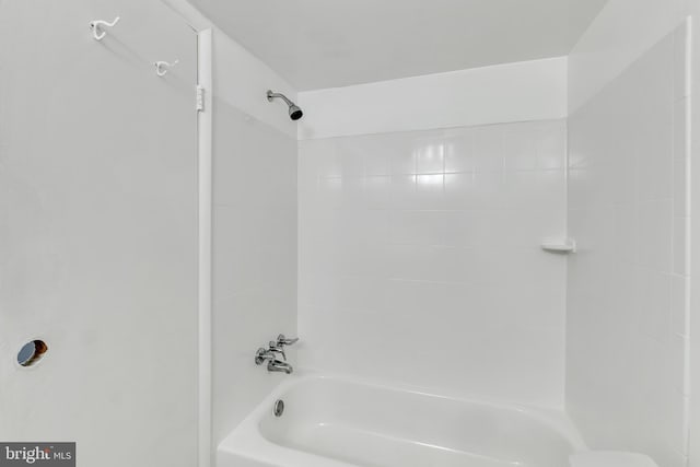 bathroom featuring tiled shower / bath combo and toilet