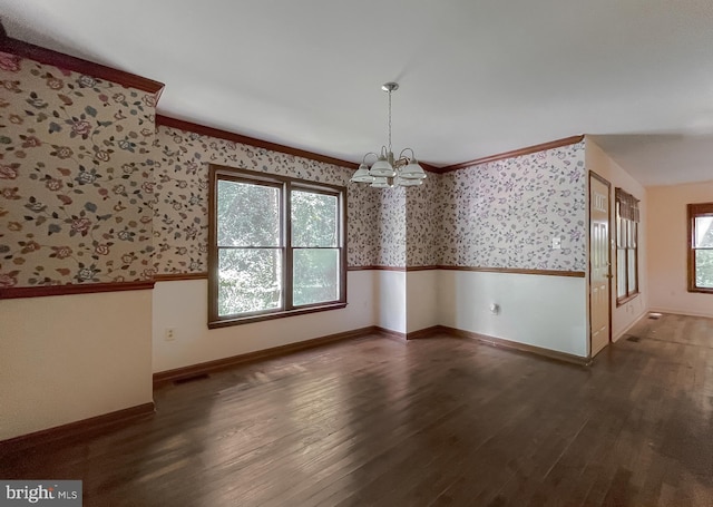 unfurnished dining area featuring dark wood-type flooring, a chandelier, and ornamental molding