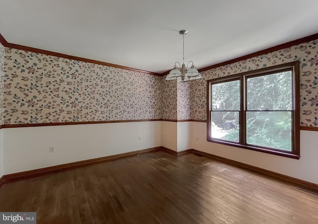 spare room with ornamental molding, a chandelier, and hardwood / wood-style flooring