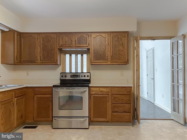 kitchen with light tile patterned floors, sink, and stainless steel electric stove