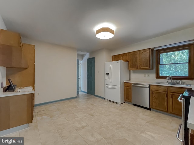 kitchen with range, sink, white refrigerator with ice dispenser, and dishwasher