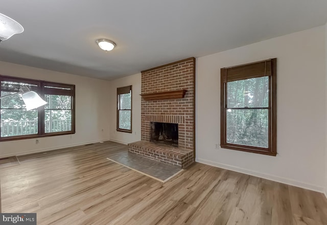 unfurnished living room featuring a fireplace and light hardwood / wood-style floors