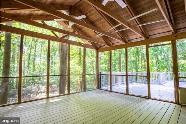 unfurnished sunroom with ceiling fan and lofted ceiling with beams