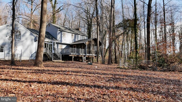 back of house featuring a wooden deck and a sunroom