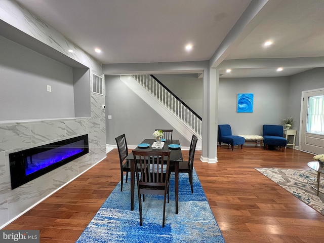 dining room with hardwood / wood-style floors and a fireplace