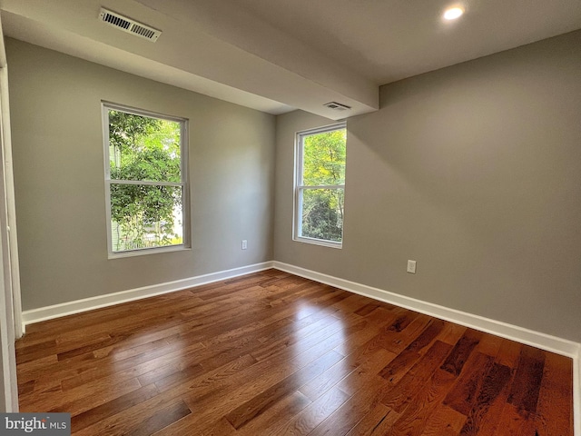 spare room with plenty of natural light and dark hardwood / wood-style floors