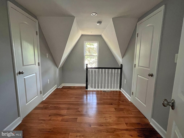 bonus room with dark hardwood / wood-style floors and vaulted ceiling