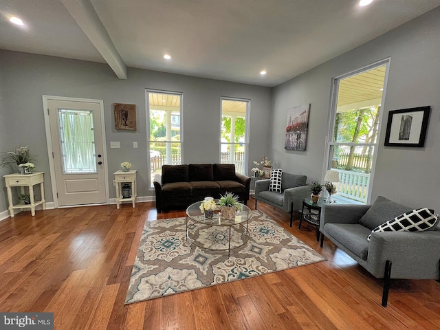 living room featuring beamed ceiling and wood-type flooring